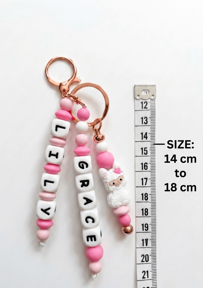 A stylish and practical baby accessory: a personalized name charm attached to a diaper bag on a stroller. The product combines identity and aesthetic design, perfectly matching modern nursery and parenting gear.