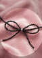 Close up of a trendy coquette bow made of 3mm faceted black tourmaline beads with solid silver accents.