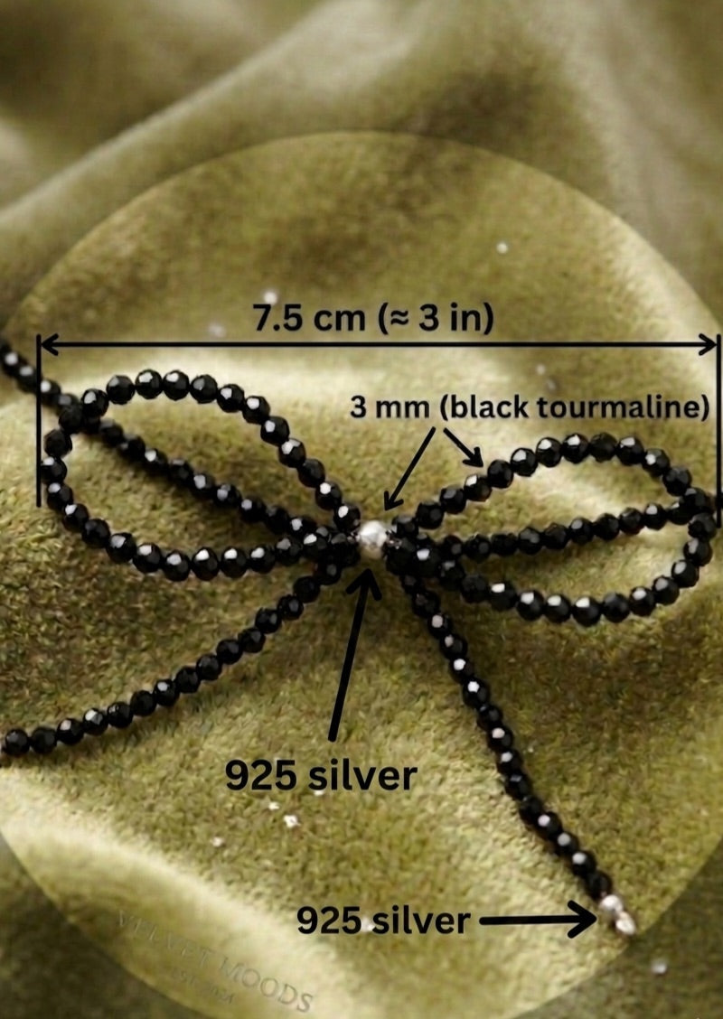Elegant protective crystal jewelry featuring a dainty black tourmaline ribbon design on a white background.