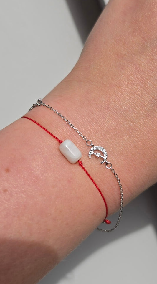 Handmade stacking bracelet set featuring a natural Moonstone red string protection bracelet with 925 sterling silver beads and a delicate crescent moon charm chain bracelet in solid 925 silver.

💡