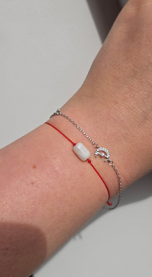 Handmade stacking bracelet set featuring a natural Moonstone red string protection bracelet with 925 sterling silver beads and a delicate crescent moon charm chain bracelet in solid 925 silver.

💡