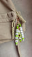Custom kids name tag made of soft silicone beads attached to a colourful school backpack.