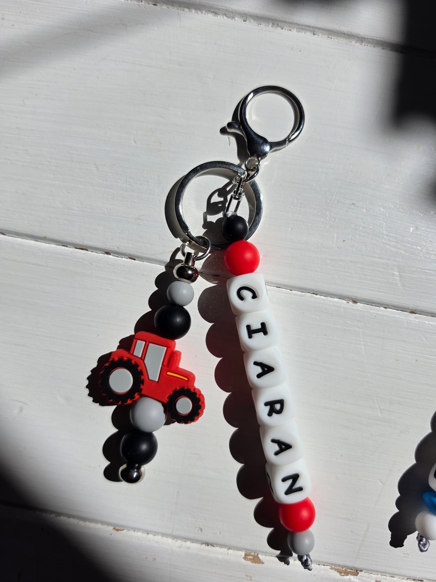 Close-up of a handmade personalised charm showing letter beads, soft-touch silicone beads, and a premium rose gold metal attachment.