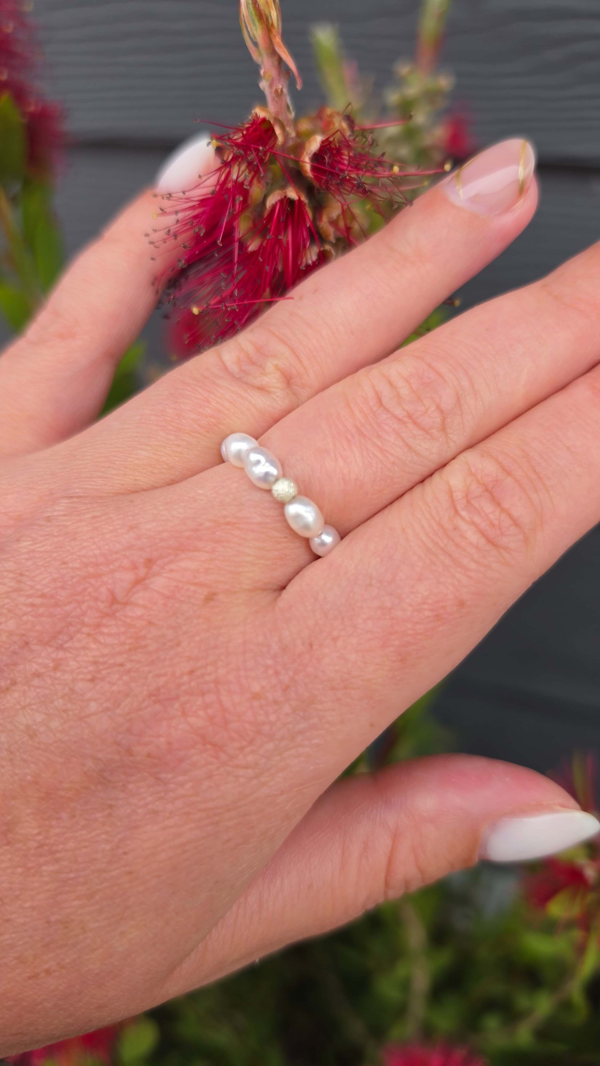 Macro photograph of natural freshwater rice pearls with a deep satin lustre, threaded on a durable stretch cord next to a diamond-cut sterling silver bead.
