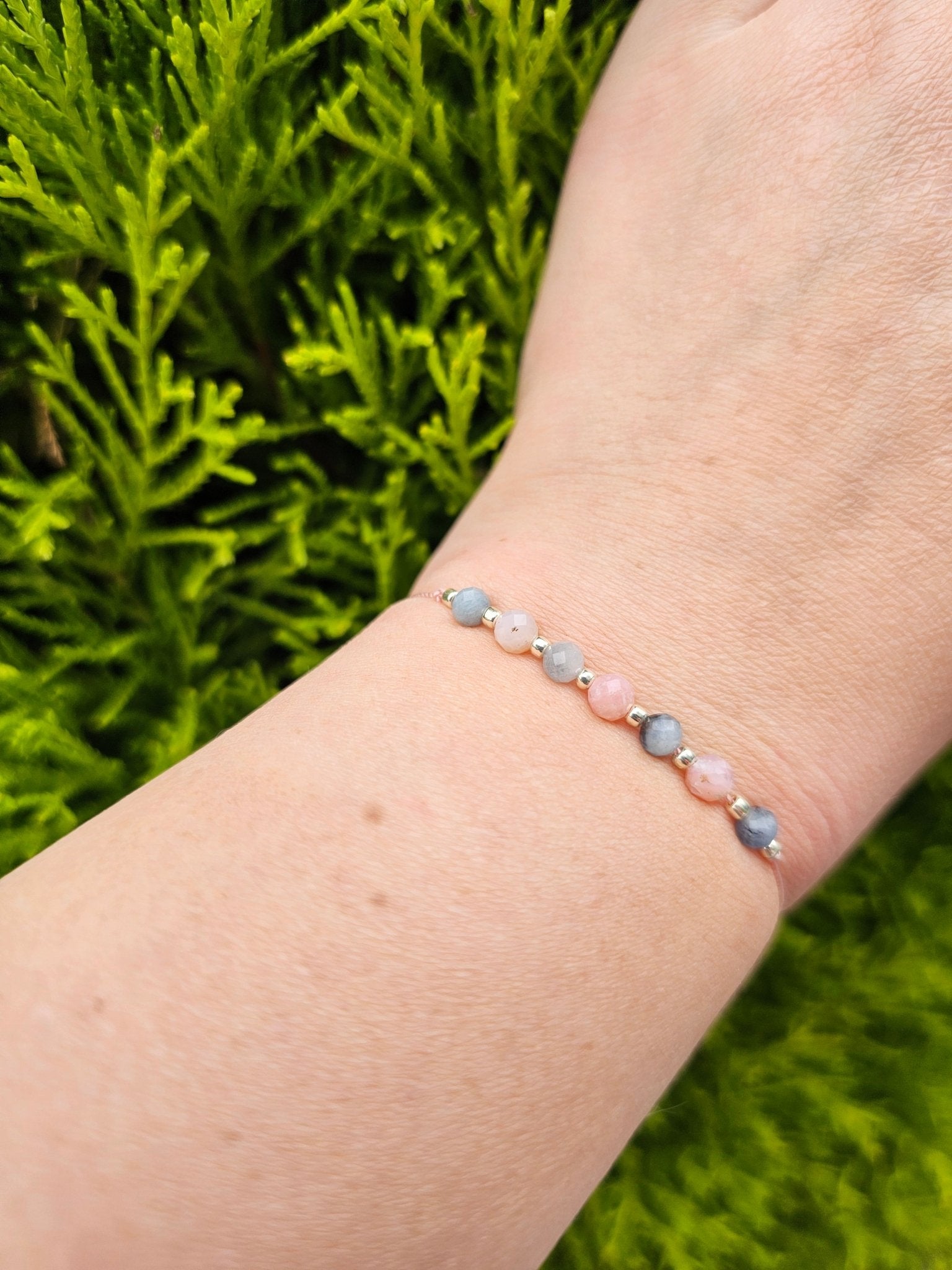 Handmade aquamarine and pink opal bracelet with sterling silver beads. Adjustable cord for comfort. Natural gemstone jewelry promoting calm, love, and creativity.