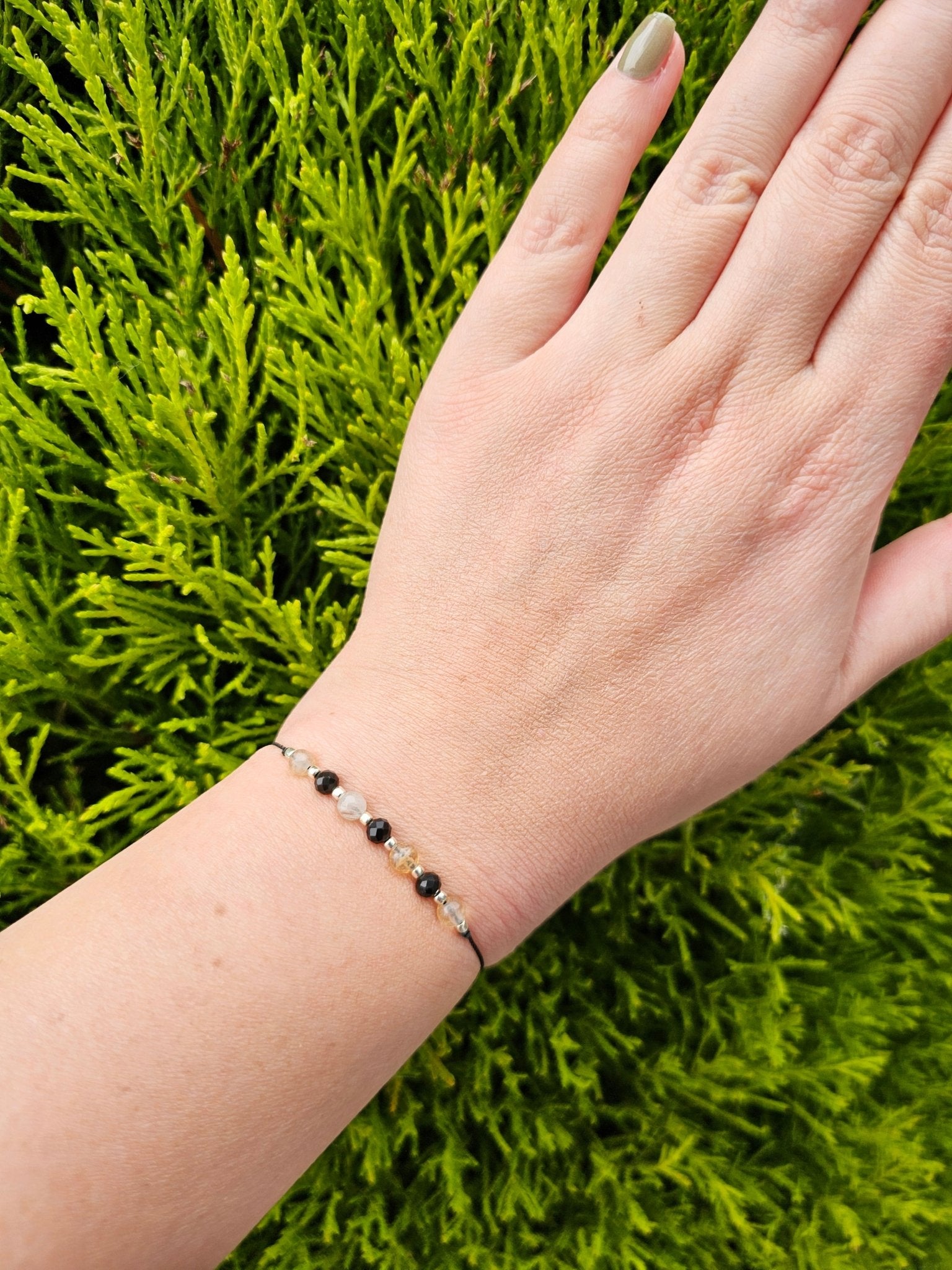 Handmade citrine and onyx bracelet with sterling silver beads. Adjustable cord for comfort. Natural gemstone jewelry promoting positivity, strength, and balance.