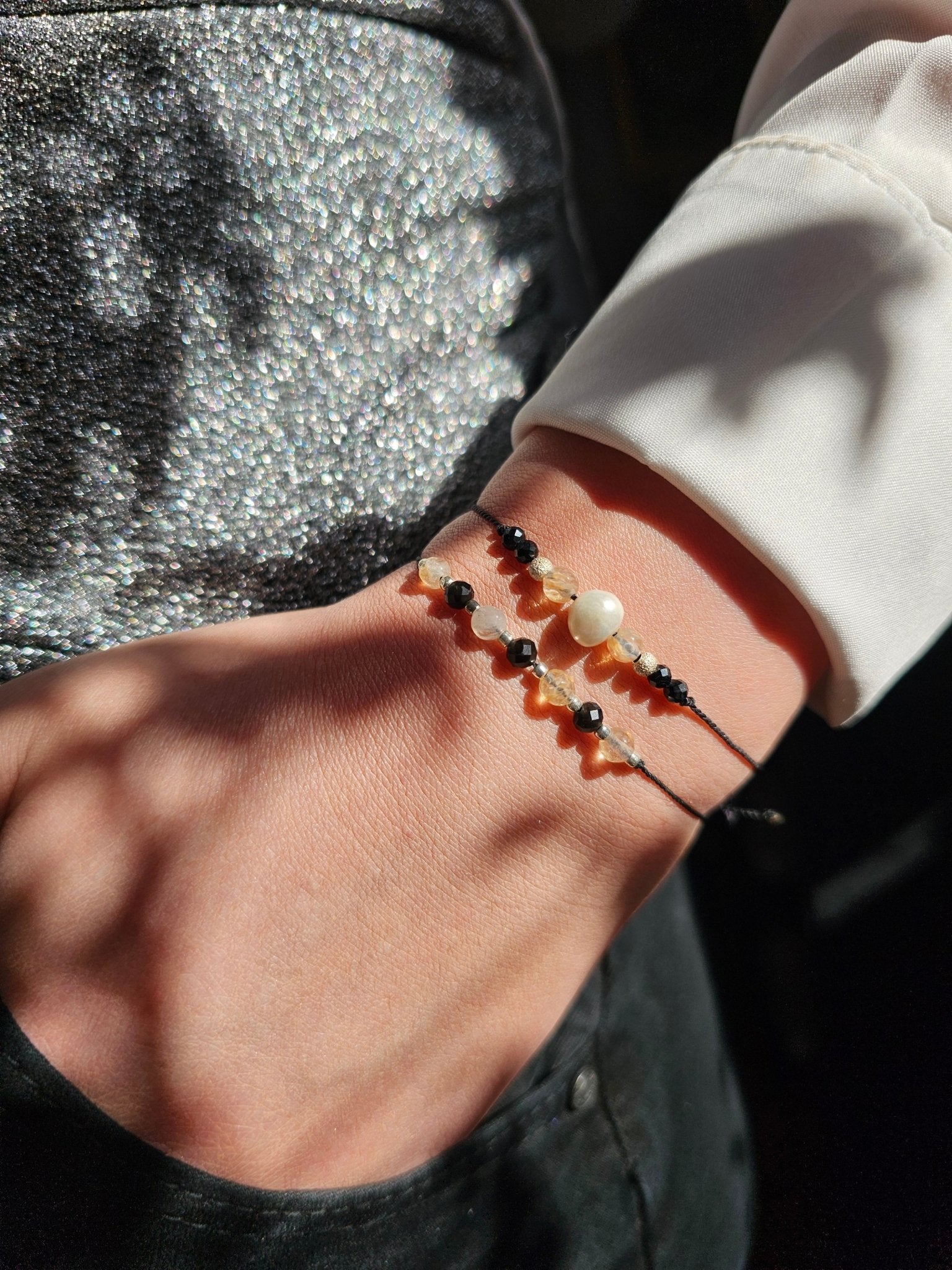 Handmade citrine and onyx bracelet with sterling silver beads. Adjustable cord for comfort. Natural gemstone jewelry promoting positivity, strength, and balance.
