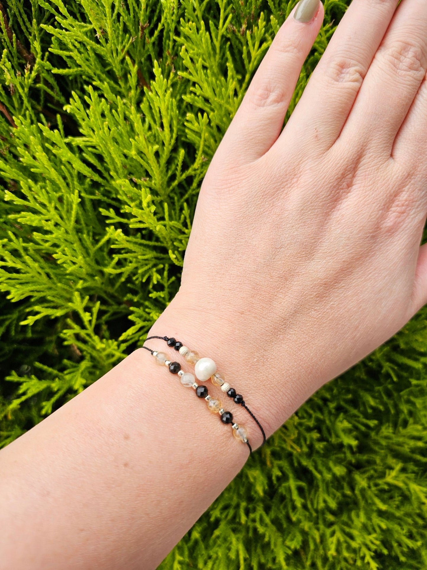 Handmade citrine and onyx bracelet with sterling silver beads. Adjustable cord for comfort. Natural gemstone jewelry promoting positivity, strength, and balance.