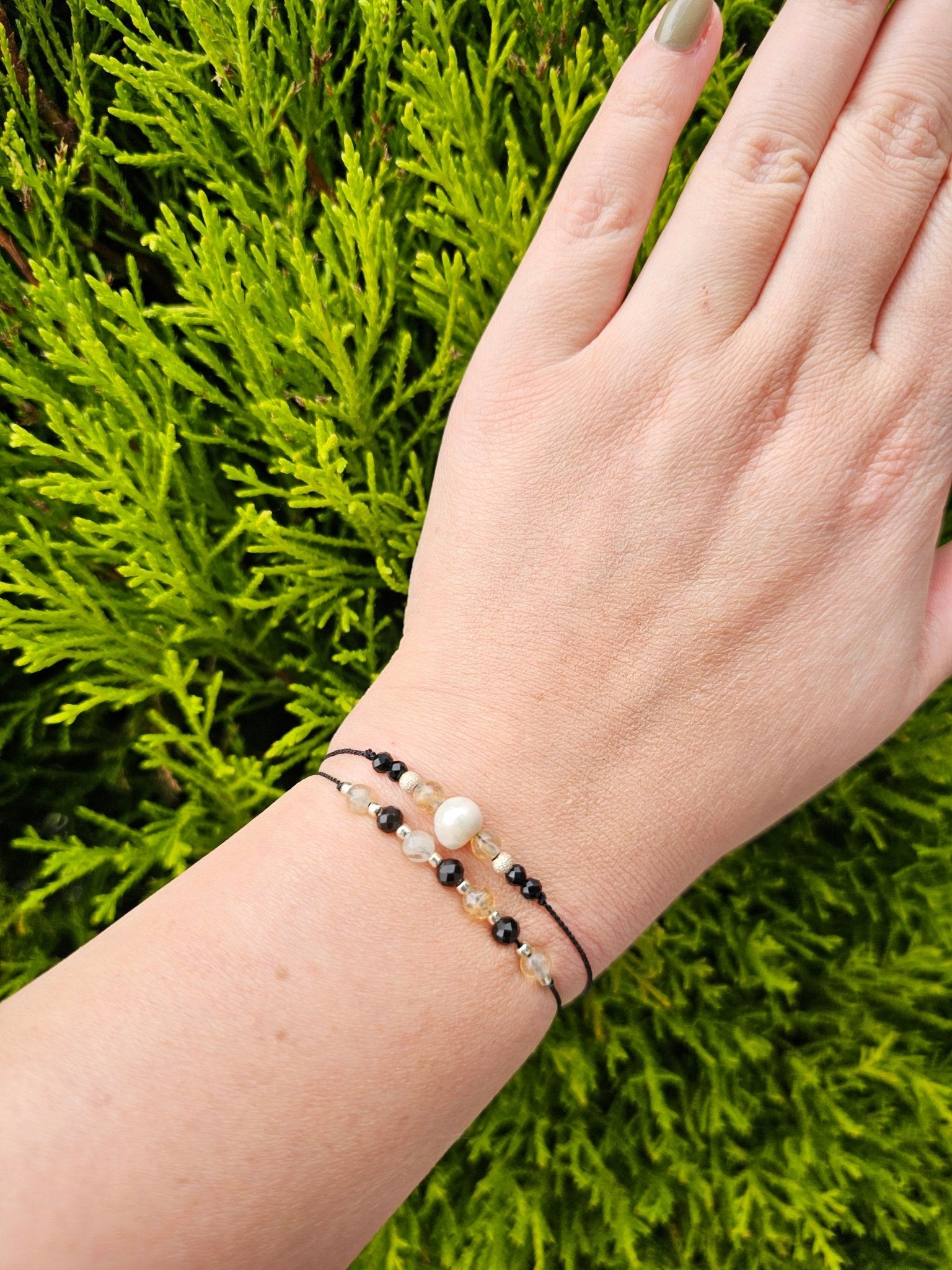 Handmade citrine and onyx bracelet with sterling silver beads. Adjustable cord for comfort. Natural gemstone jewelry promoting positivity, strength, and balance.