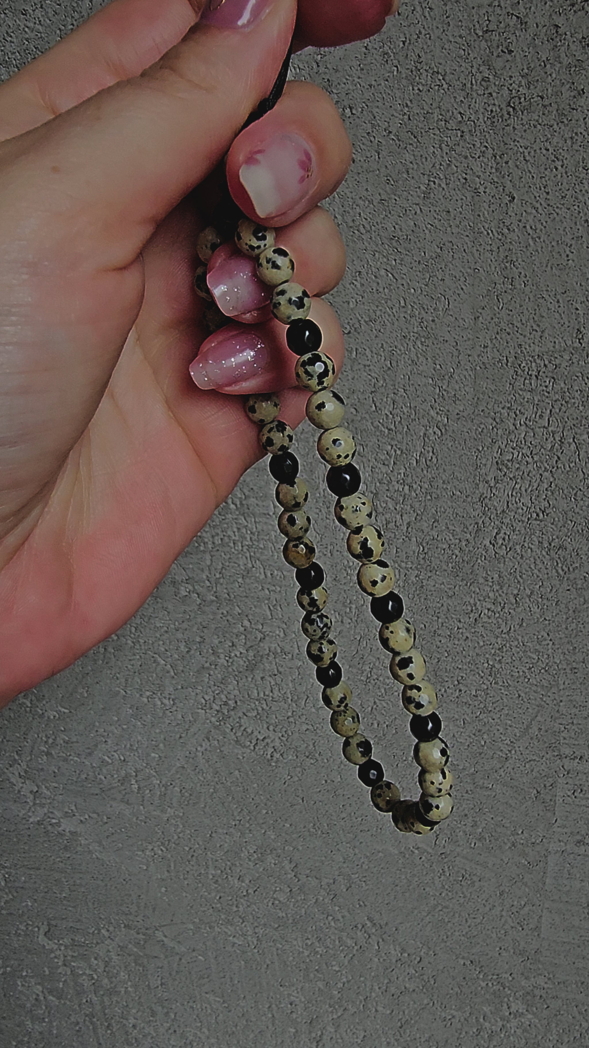 Natural crystal charm with black onyx and dalmatian jasper beads on a cord – grounding, protective and calming gemstone accessory.