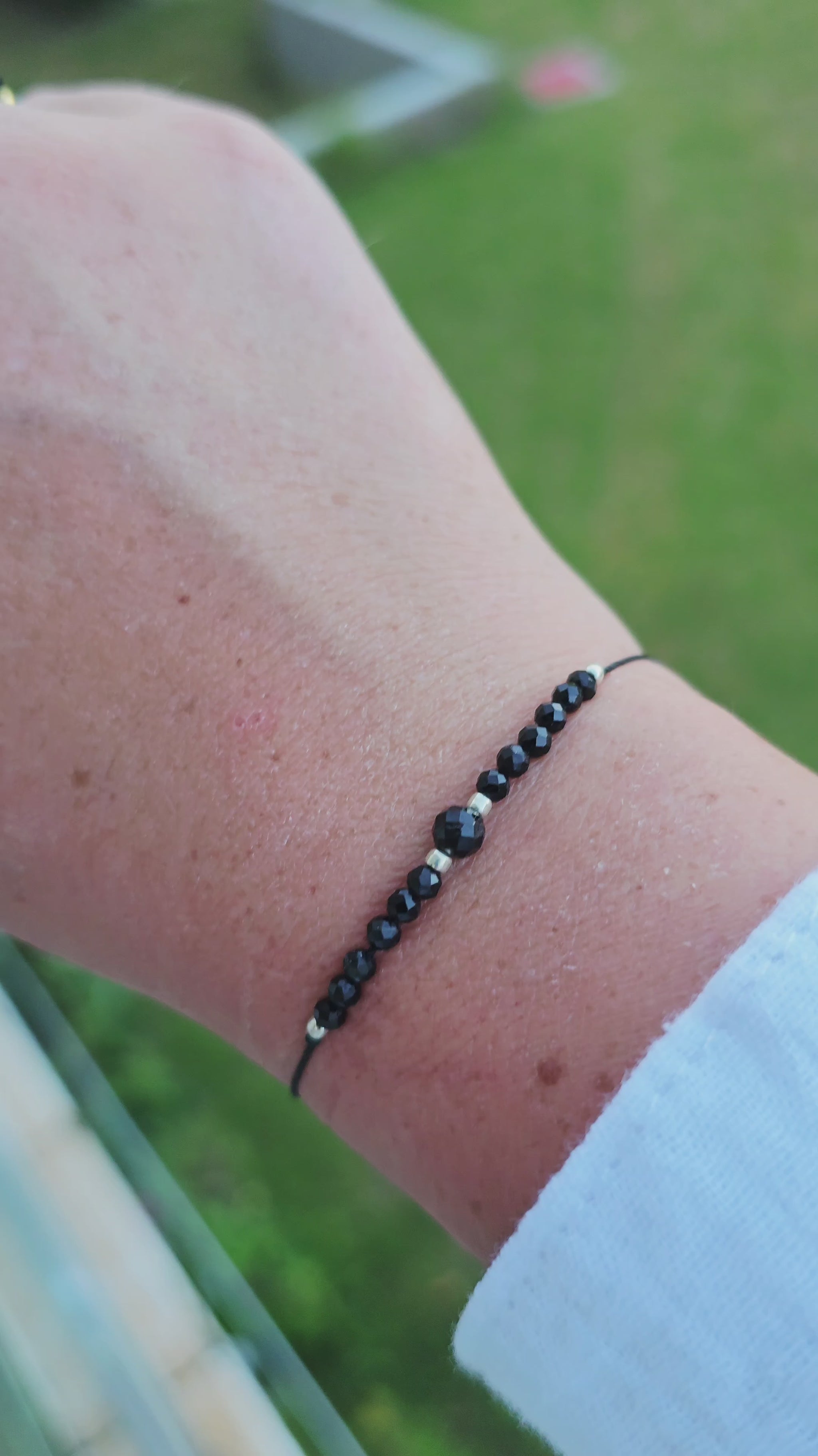 Handcrafted gemstone bracelet on black cord, ready for gifting.