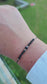 Handcrafted gemstone bracelet on black cord, ready for gifting.