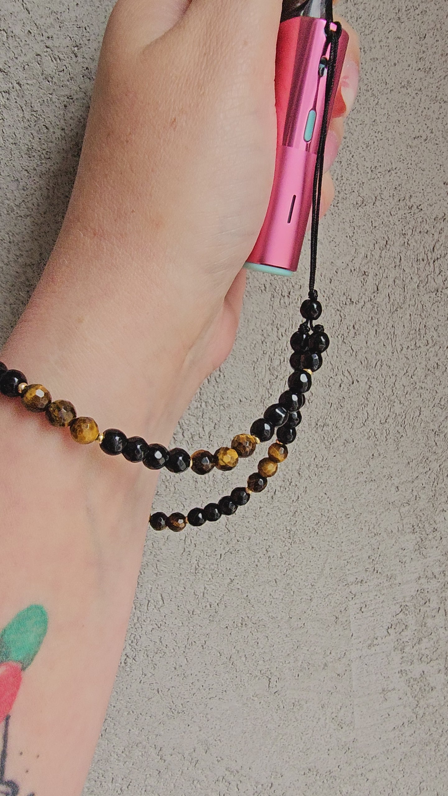 Handmade crystal charm with black onyx and tiger’s eye beads, gold accents, and cord – used as a protective and calming accessory for phone, keys or bag.