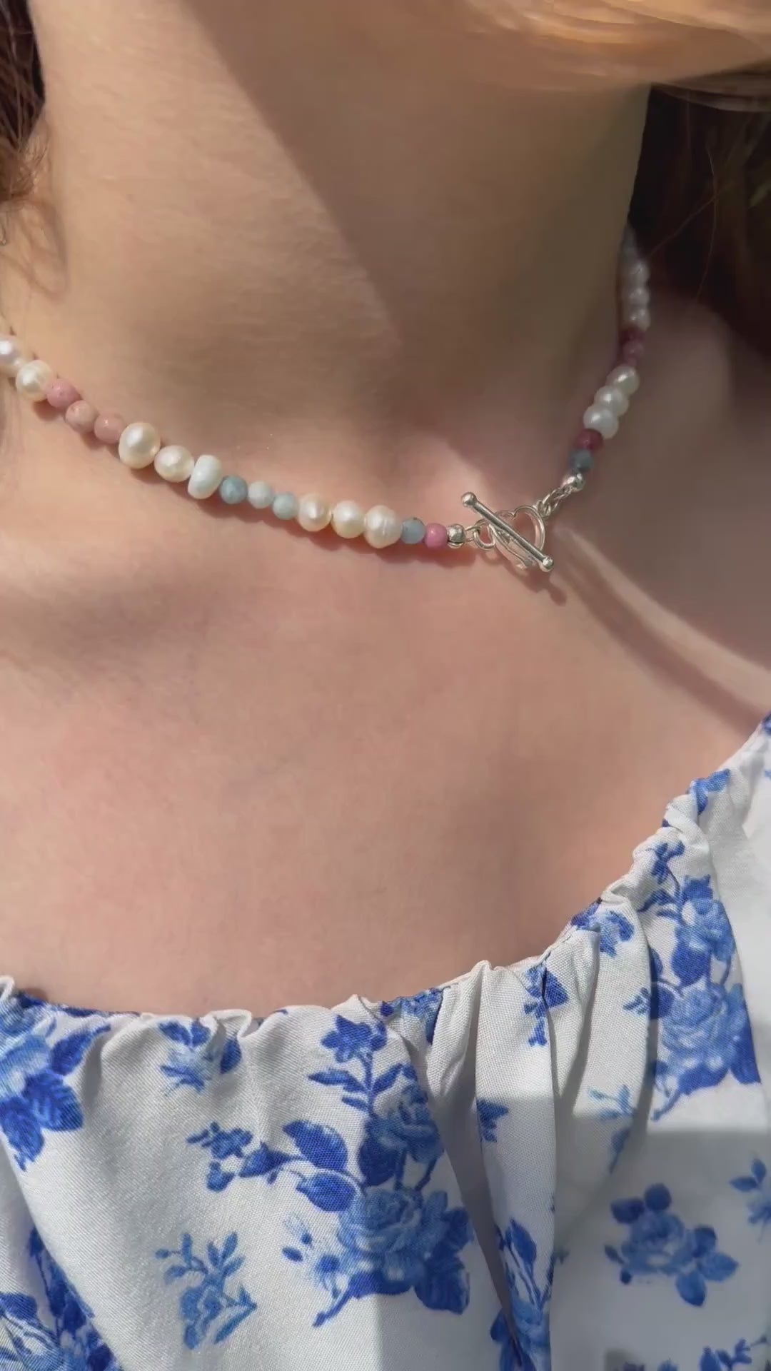 Close-up of handmade choker necklace with freshwater pearls, aquamarine and rhodonite gemstones, finished with 925 sterling silver heart toggle clasp. Comes in velvet pouch with silver cleaning cloth. Irish handmade gift-ready jewellery.